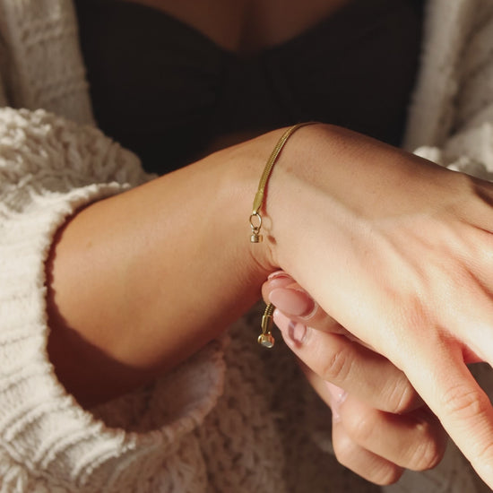 Model Clasping a LucyKitty Gold Filled Mira Fine Herringbone Bracelet